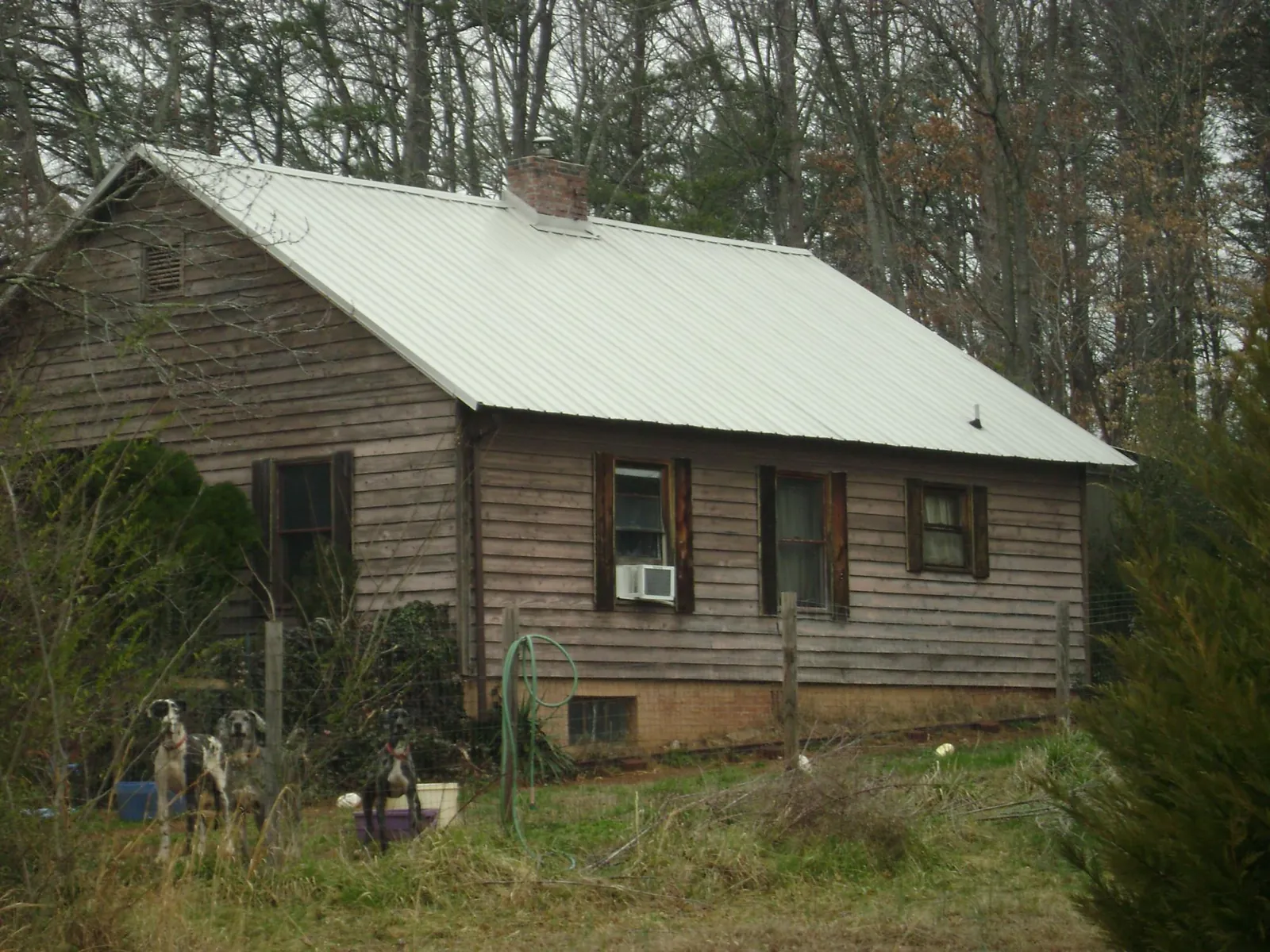 White metal roof on an old wood sided farmhouse, from a Metal Roof Installation job in Clarkston